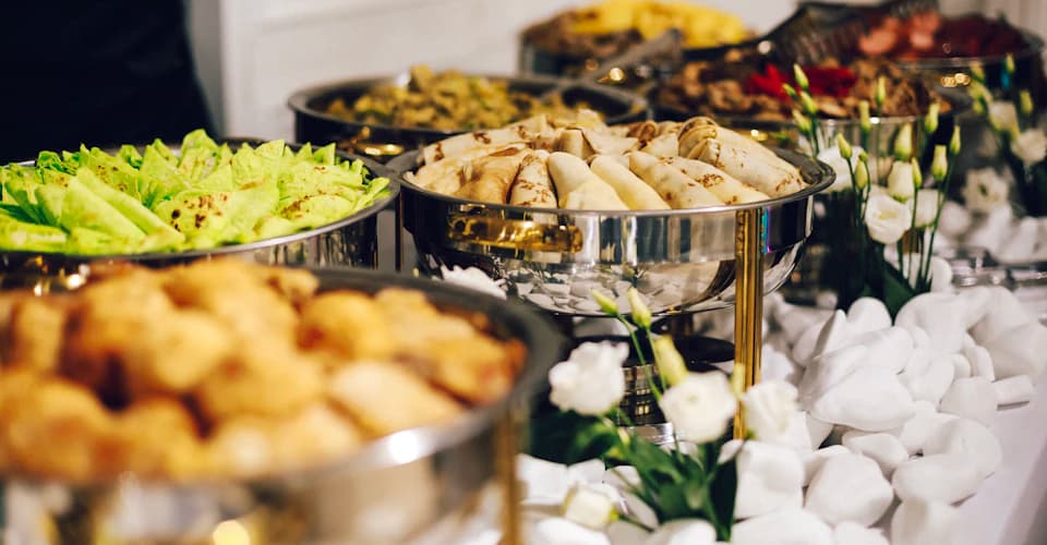 Desi wedding buffet laid out in chafing dishes