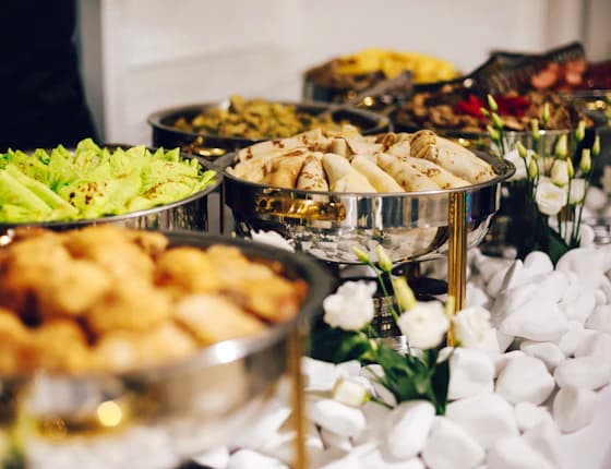 Desi wedding buffet laid out in silver chafing dishes